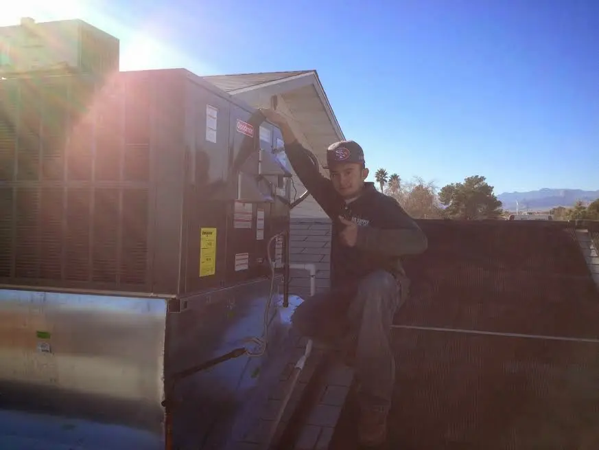 HVAC technician performing AC Tune-Up on a rooftop unit in Estherville
